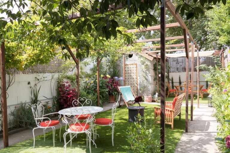 alt - Picture of the garden at Vila Camélia on a summer's day, with the tables set up and the lawn cleaned and filled with flowers. A real haven of peace in the middle of Porto !